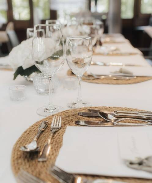 festlich eingedeckter Tisch des Restaurants Remsstuben mit weißen Tischdecken und weißem Geschirr, Weingläsern, siblernes Bestck und weißer Blumendeko
