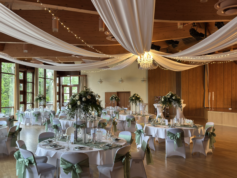 Der Welfensaal in festlich eingedeckter Galabetischung mit Deckendekoration und Beleuchtung.